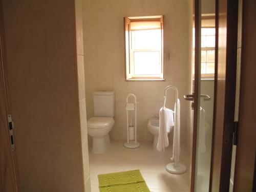 a bathroom with a toilet and a window at Cantinho da Estrela in Seia