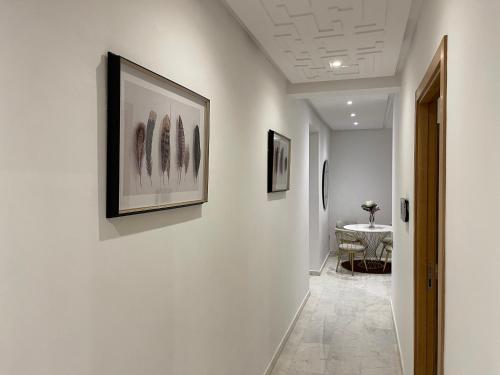 a hallway with art on the walls and a table at NEW SUPER LUXURY APARTMENT (CENTRAL MARRAKECH) in Marrakesh