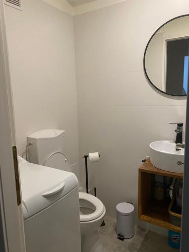 a white bathroom with a toilet and a sink at Astra 1bedroom in Braşov