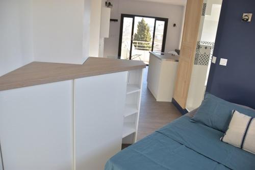 Cet appartement comprend une chambre avec un lit et une cuisine avec un comptoir. dans l'établissement PETIT LOFT Antibes, à Antibes
