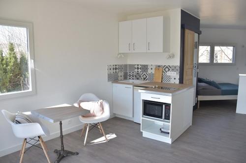 - une cuisine avec une table, une table et des chaises dans l'établissement PETIT LOFT Antibes, à Antibes