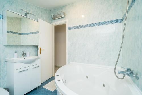 a bathroom with a white tub and a sink at Deluxe Duplex House With Terrace in Dubrovnik