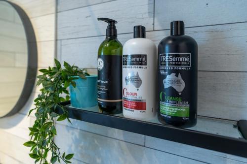 three bottles of cleaning products sitting on a shelf at HolidayRento Bondi Beach Ocean View Rooftop Pool in Sydney
