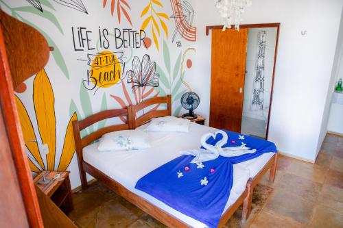 a bedroom with a bed with a painting on the wall at Cumbuco Kite in Paradise e Hospedaria in Cumbuco