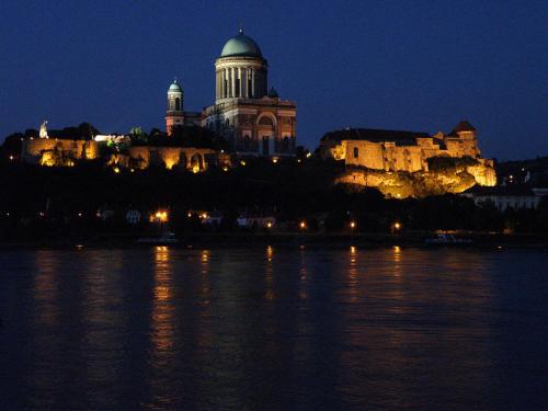 a building on a hill next to the water at night at Hunter in Štúrovo