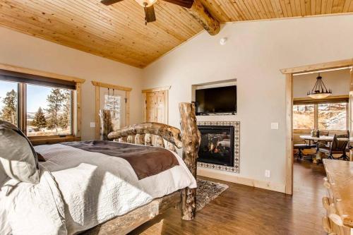 a bedroom with a bed and a fireplace at Pikes Peak Resort - Bear Den Cabin - Where Luxury and Wilderness Meet in Westcreek