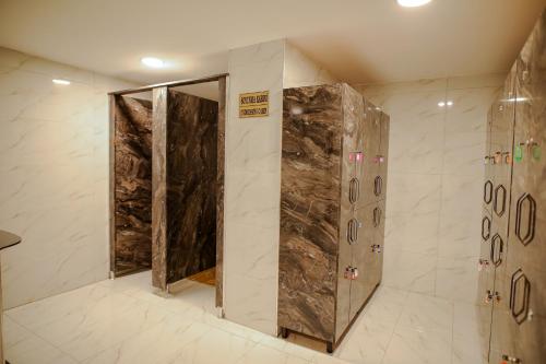a walk in shower in a bathroom with marble walls at Emin Koçak Hotel Kapadokya in Nevşehir