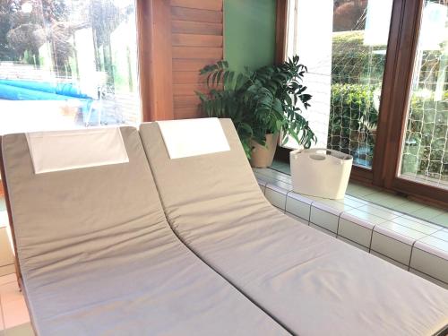 a white couch sitting in front of a window at Spa Residence Carbona Apartman 104 in Hévíz