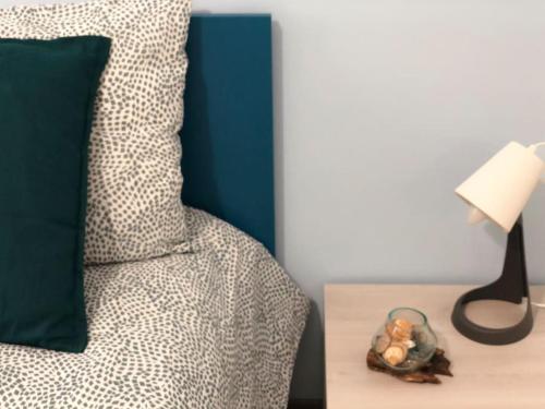 a bed with a green pillow and a table with a lamp at Tabula House - 4 ELEMENTS in Catania