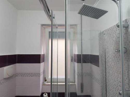 a bathroom with a shower with a glass door at Tabula House - 4 ELEMENTS in Catania