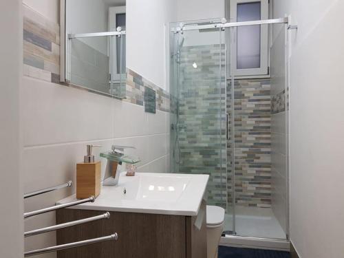 uma casa de banho com um lavatório e uma cabina de duche em vidro. em Tabula House - 4 ELEMENTS em Catânia