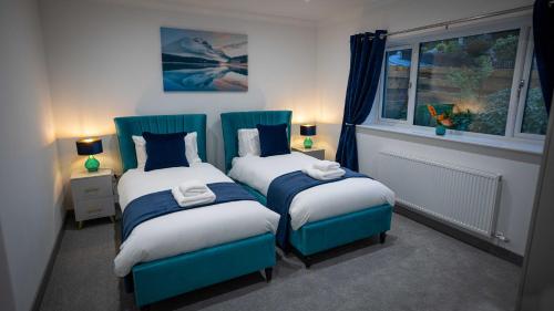 a bedroom with two twin beds and a window at Heather House , luxury holiday house in Pitlochry in Pitlochry
