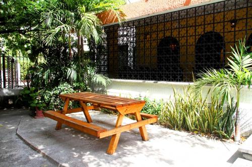 a wooden picnic table and bench in a garden at La Guaca Hostel Santa Marta in Santa Marta