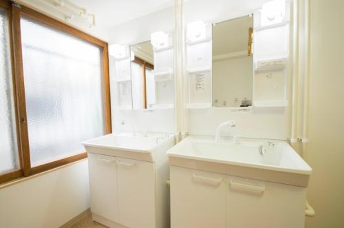 un bagno con lavandino, specchio e finestra di TOMA HOUSE - Vacation STAY 8723 a Sapporo