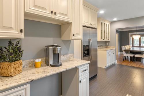 a kitchen with white cabinets and a coffee maker on a counter at Gorgeous Downtown Bungalow, Walk Everywhere!!! in Lake Geneva