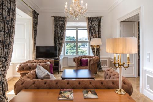 a living room with a couch and a table at Schloß Schönbrunn Grand Suite in Vienna