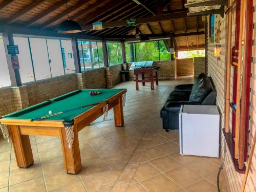 a living room with a pool table and a couch at Casa espaçosa com sala de jogos interna e externa in Florianópolis