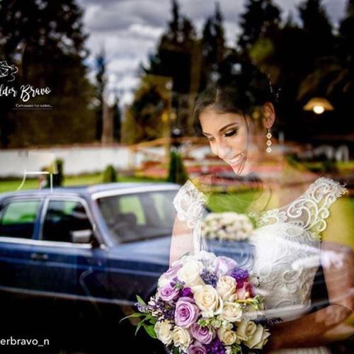 a woman holding a bouquet of flowers and a car at Casa d'Campo Tababela Hotel Boutique in Tababela