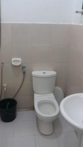 a bathroom with a white toilet and a sink at RGR CAMIGUIN TRAVEL TOUR SERVICES AND PENSION HOUSE in Mambajao