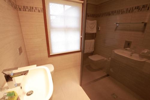 a bathroom with a sink and a toilet and a window at Cable Station Accommodation in Stanley