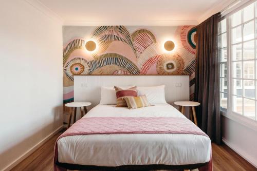 a bedroom with a large bed with two tables at Nelson Palms in Nelson Bay