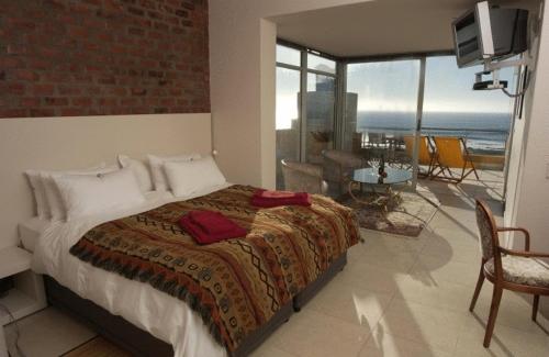 a bedroom with a bed and a view of the ocean at Crayfish Lodge Sea & Country Guest House in Gansbaai