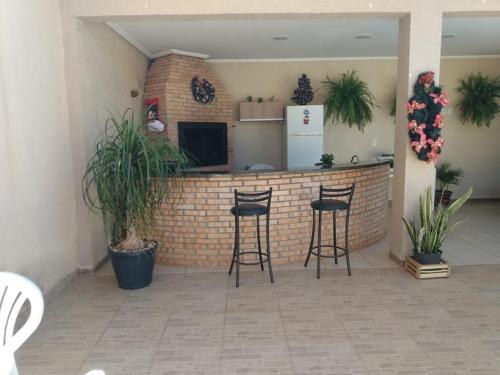 un bar en una habitación con sillas y plantas en Edicula com um quarto banheiro e piscina e lazer, en Foz do Iguaçu