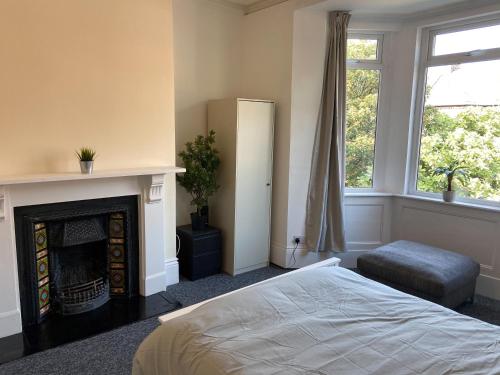 a bedroom with a fireplace and a bed and a window at Newcastle Apartment 2 - Free Parking in Old Walker