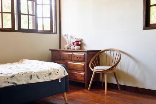 a bedroom with a bed and a chair and a dresser at Nongsa Village Peaceful Villa in private beach Resort in Nongsa
