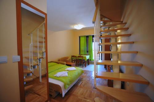 a room with a bed and a spiral staircase at Apartments Unija Duga Uvala in Krnica