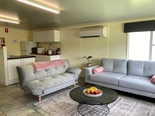 a living room with two couches and a table at Happy Pig Farm in Stanthorpe