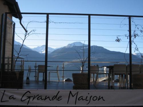 a balcony with a table and chairs and a view of the mountains at La Grande Maison in Savièse