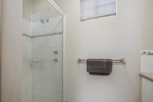 a bathroom with a shower with a glass door at The Cove Holiday Village in Point Samson