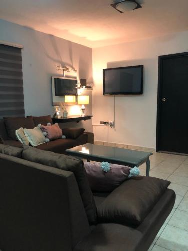 a living room with a couch and a tv on the wall at Loft Bonhomia with parking 7min to downtown in Guanajuato