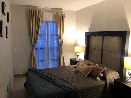 a bedroom with a bed with a teddy bear on it at Loft Bonhomia with parking 7min to downtown in Guanajuato
