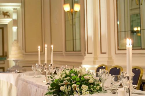 a table with white candles and flowers on it at The Midland Hotel in Bradford