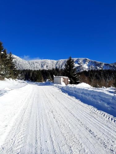 a snow covered road with a building in the distance at Семеен хотел Кристал in Smolyan