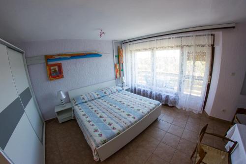 a small bedroom with a bed and a window at Apartments Stefanovski Paradiso in Veli Lošinj