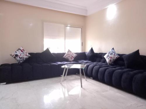 sala de estar con sofá negro y mesa en Apartment with Terrace en Casablanca