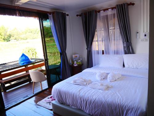 a bedroom with a bed with two stuffed animals on it at Nansilarom in Ban Bun Yun