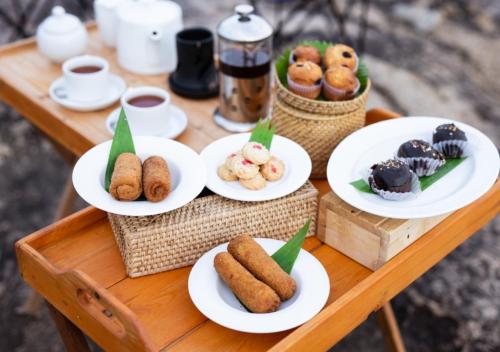 a table with plates of pastries and cups of coffee at Tribe Yala - Luxury Camping in Yala