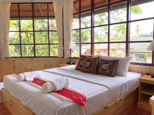 ein Schlafzimmer mit einem großen Bett mit Handtüchern darauf in der Unterkunft Ekman Garden Resort in Sichon