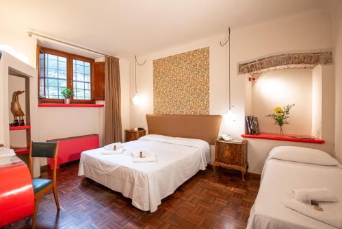 a hotel room with two beds and a table at Hotel Diana in Lucca