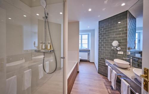 a bathroom with a shower and a toilet and a sink at Hotel Zur Post Altötting in Altötting