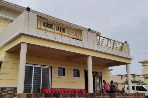 a house with a balcony on top of it at Riddhi Sea View Bungalow Ganpatipule for Family in Ratnagiri