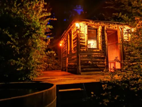 a log cabin at night with lights on it at Zabola Estate - Transylvania in Zăbala