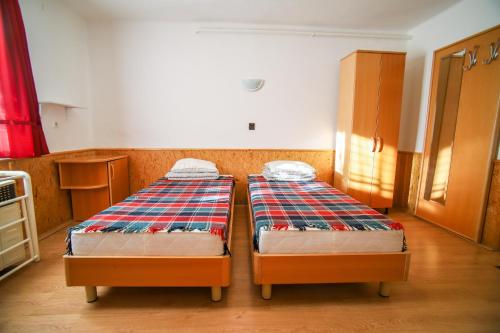 two twin beds in a room with a kitchen at Panoráma Üdülő in Aggtelek