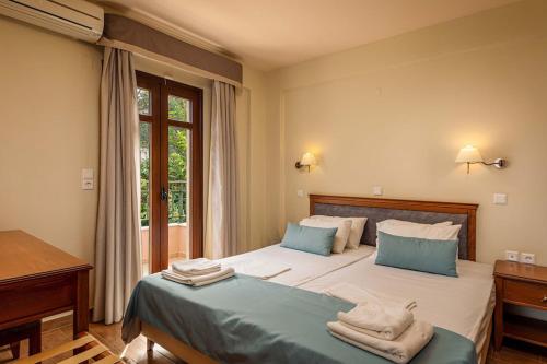 a bedroom with a bed and a desk and a window at Mikra Anogia Villas in Rethymno Town