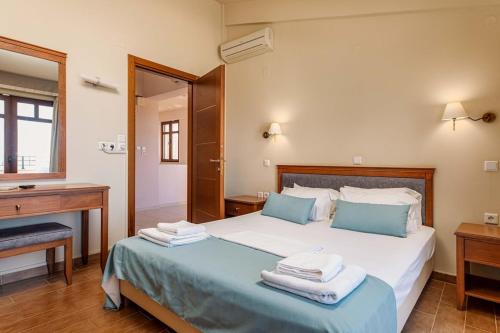 a bedroom with a bed with towels on it at Mikra Anogia Villas in Rethymno Town