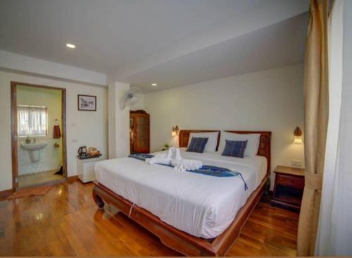
a hotel room with a bed, chair, and nightstand at Rustic River Boutique in Chiang Mai
